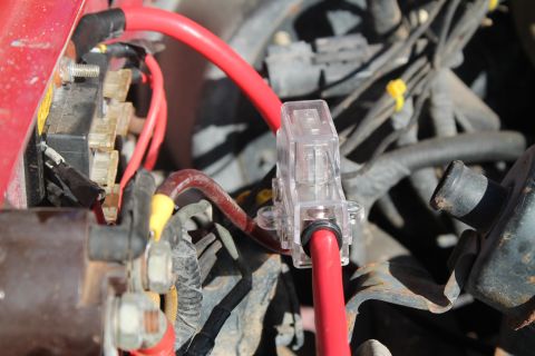 1990 Ford Bronco - Automotive wiring detail showing a fuse box and red power cables.