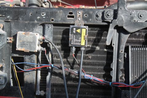 1990 Ford Bronco - Aftermarket HID ballast and wiring are visible in front of a vehicle's radiator.