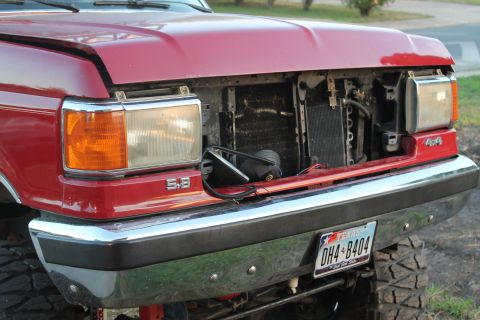 1990 Ford Bronco - Front view of a red 1990 Ford Bronco, showing the 5.8 badge and the open grille area.