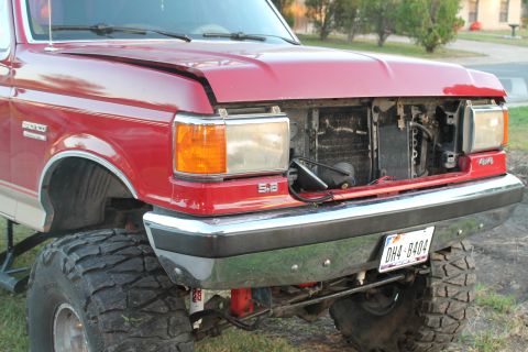 1990 Ford Bronco - Front view of a red 1990 Ford Bronco, missing its grille, with a 5.8 badge visible.