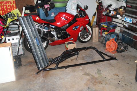 1990 Ford Bronco - A Ford Bronco grille and a black roll bar are shown in a garage setting with a red motorcycle.
