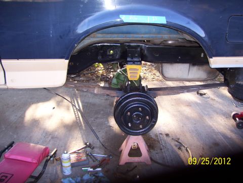 1990 Ford Bronco - Close-up of a vehicle's rear suspension and axle assembly during maintenance.
