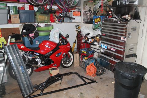 1990 Ford Bronco - A red sport motorcycle is the main subject in this garage scene, surrounded by tools and storage.