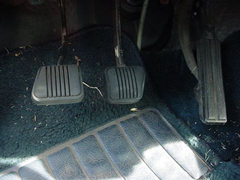 1991 Ford LTD Crown Victoria - Close-up of the foot pedals inside a vehicle's cabin.