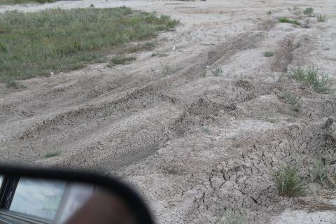 1990 Ford Bronco - Tire tracks mark the dry, cracked earth, suggesting off-road travel.