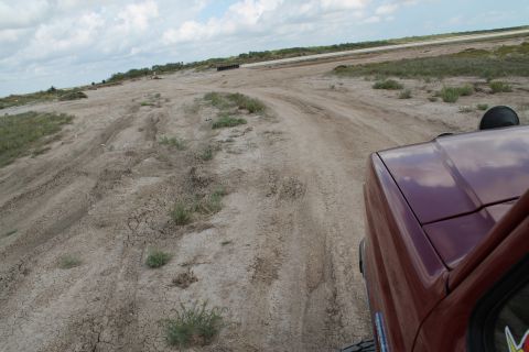 1990 Ford Bronco - Driving on a dry, cracked dirt road under a cloudy sky.