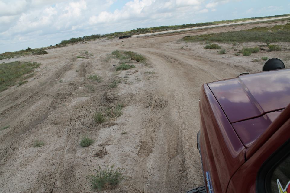 Red SUV's hood and fender on a dirt road