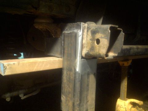 1995 Ford Bronco - Close-up view of a custom-welded metal bracket attached to a vehicle's frame, likely for suspension modification.