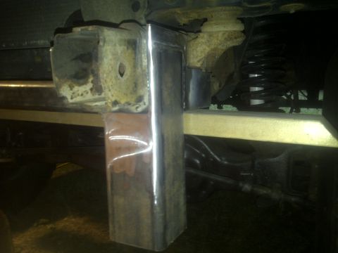 1995 Ford Bronco - Custom metal bracket welded onto the frame of a vehicle, near suspension parts.