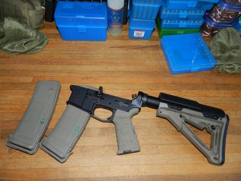 1996 Ford Bronco - AR-15 lower receiver assembly with magazines and accessories on a wooden surface.