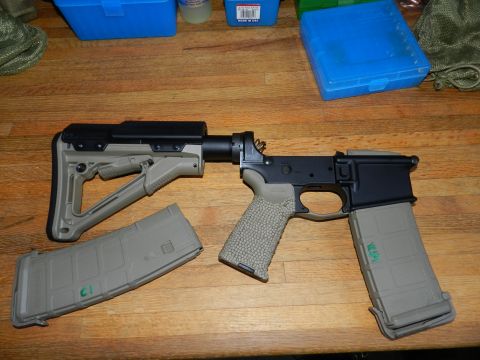 1996 Ford Bronco - An AR-15 lower receiver assembly with a stock and two magazines is laid out on a wooden table.
