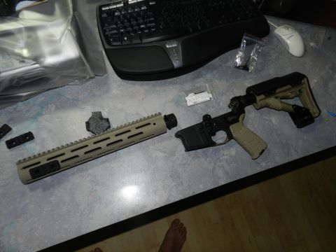 1996 Ford Bronco - AR-15 lower receiver and handguard laid out on a desk next to a keyboard and mouse.