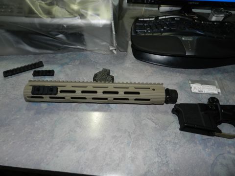1996 Ford Bronco - AR-15 handguard and lower receiver parts are laid out on a desk next to computer peripherals.