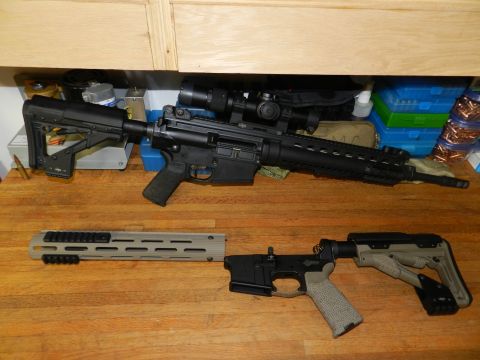 1996 Ford Bronco - Two AR-15 rifle components are laid out on a wooden table, with ammunition boxes in the background.