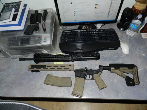 1996 Ford Bronco - Disassembled assault rifle components and magazines are laid out on a desk next to a computer setup.