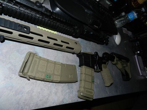 1996 Ford Bronco - Several firearms and magazines are laid out on a table, with a water bottle and computer accessories in the background.