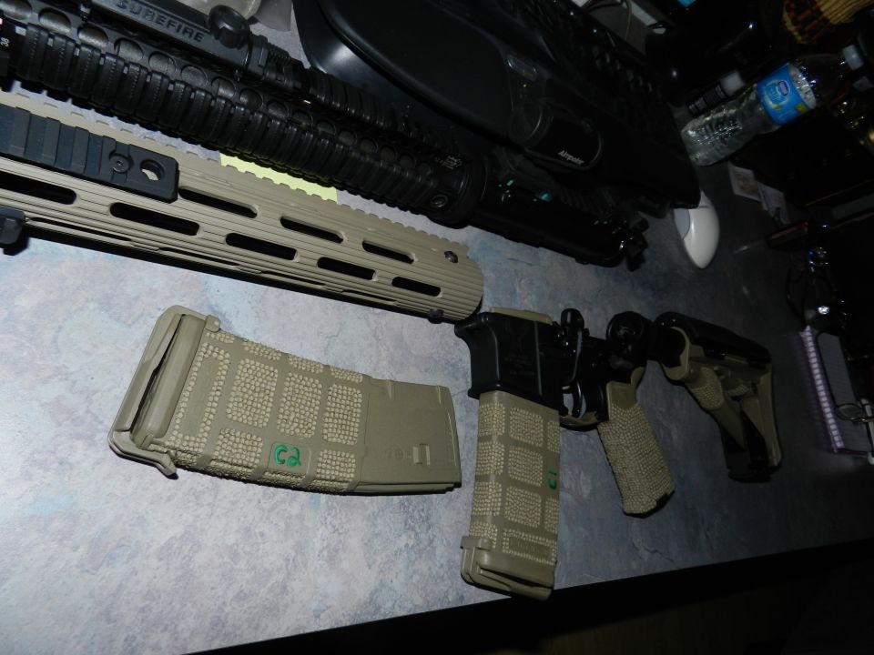 AR-15 style rifle with two magazines and a pistol on a table