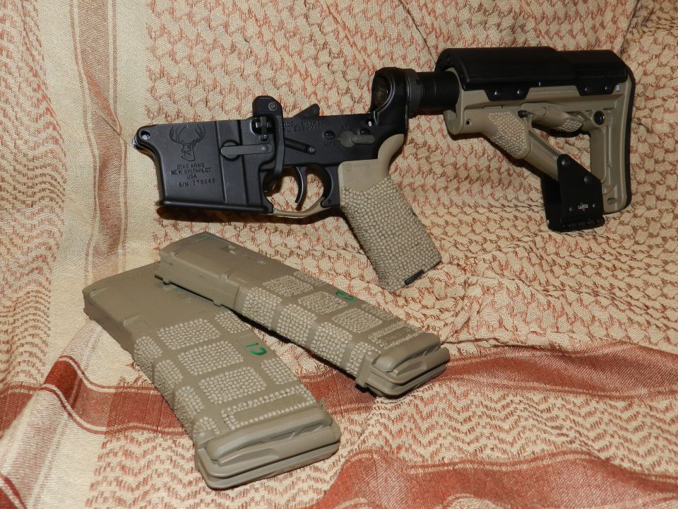 AR-15 lower receiver with deer logo and two magazines on patterned fabric