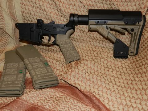 1996 Ford Bronco - An AR-15 lower receiver assembly with an adjustable stock and two magazines are displayed on a patterned cloth.