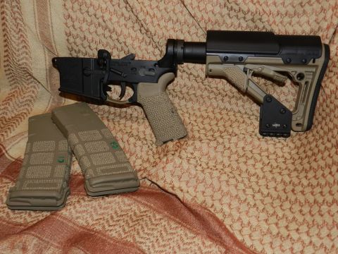 1996 Ford Bronco - An AR-15 lower receiver and two magazines are displayed on a patterned cloth. The Supermotors.net logo is in the lower right corner.