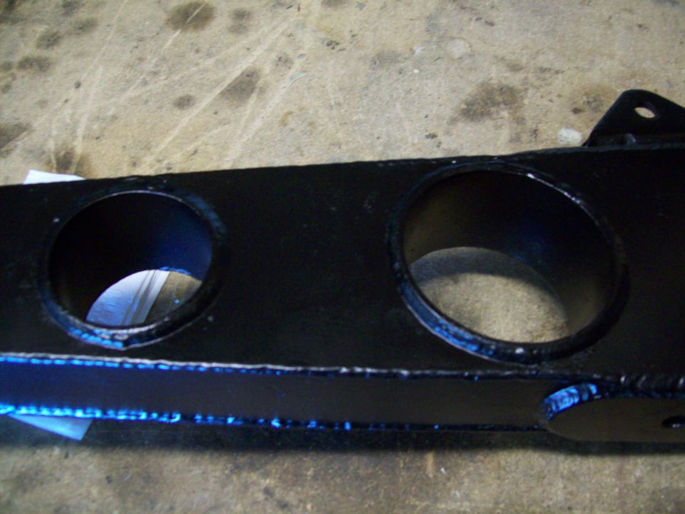Black metal bracket with two large circular holes and a mounting tab