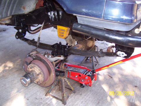 1990 Ford Bronco - Close-up view of the rear suspension and brake assembly of a 1990 Ford Bronco undergoing maintenance.