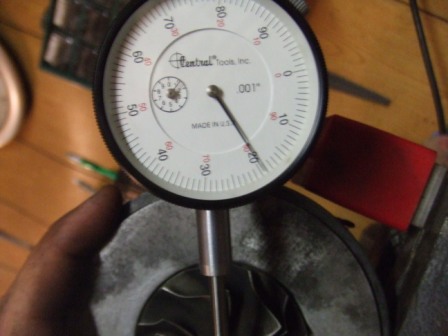 1996 Ford Bronco - A dial indicator is used to measure a mechanical part, indicating precision measurement.