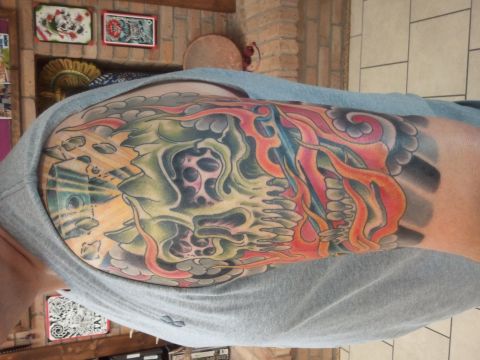 1967 Ford Mustang - A colorful tattoo of a skull and flames covers a person's arm.