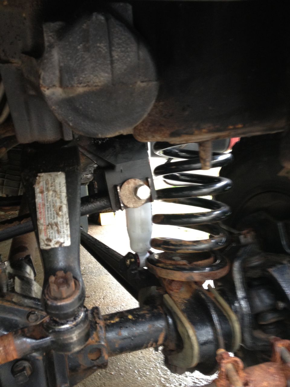 Close-up of rusty suspension parts including a coil spring and shock absorber