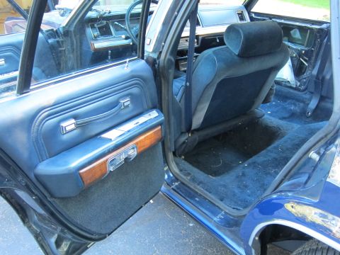 1991 Ford LTD Crown Victoria - The interior of a blue sedan is shown with the driver's side door open, revealing the seats and floor.