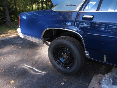 1991 Ford LTD Crown Victoria - Rear view of a blue sedan with a partially open trunk and chrome trim details.