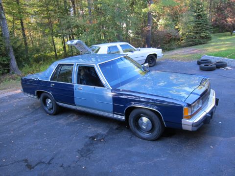 1991 Ford LTD Crown Victoria - A two-tone blue 1991 Ford Crown Victoria LTD sedan is parked outside with another vehicle in the background.