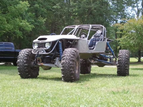 1967 Ford Mustang - Custom off-road buggy with a roll cage and oversized tires sits on grassy terrain.