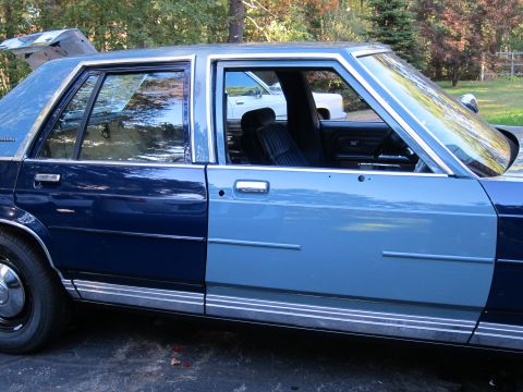 1991 Ford LTD Crown Victoria - Side view of a two-tone blue 1991 Ford Crown Victoria LTD, with its trunk open.