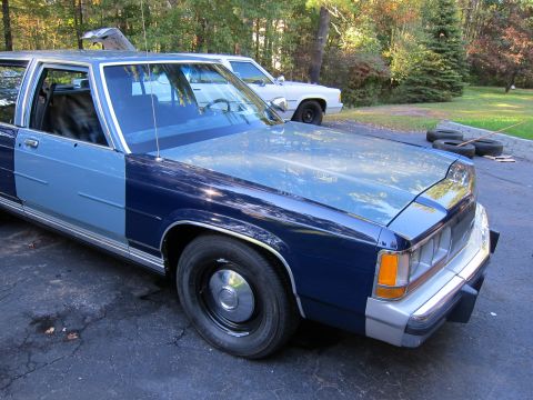 1991 Ford LTD Crown Victoria - A two-tone blue 1991 Ford Crown Victoria LTD sedan is parked in a driveway next to another vehicle.