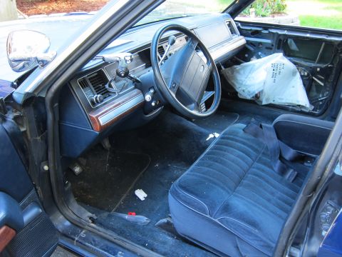 1991 Ford LTD Crown Victoria - The interior of a 1991 Ford Crown Victoria LTD shows a blue velour seat and a disassembled dashboard area.