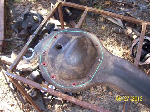 1990 Ford Bronco - This photo shows a differential housing and other automotive parts scattered on the ground.