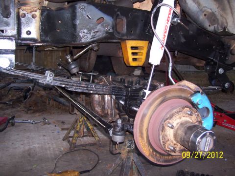 1990 Ford Bronco - Front suspension and brake assembly of a Ford Bronco, likely undergoing maintenance or modification.