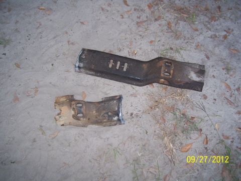 1990 Ford Bronco - Two metal brackets, possibly from a vehicle, lie on the ground with scattered leaves and grass. The date 09/27/2012 is visible.