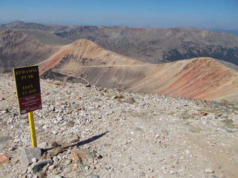 1986 Ford Bronco II - A vast mountain vista under a clear blue sky, with a sign marking Red Cone Peak.