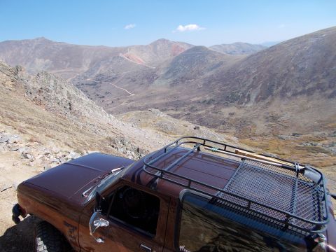 1986 Ford Bronco II - 1986 Ford Bronco II parked on a mountain trail with a scenic overlook.