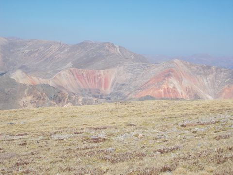 1986 Ford Bronco II - Vast mountain landscape with colorful geological formations and dry grass in the foreground.