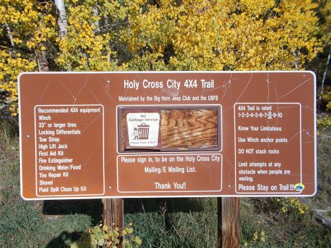 1986 Ford Bronco II - A sign for the Holy Cross City 4x4 Trail provides trail rating and equipment recommendations.