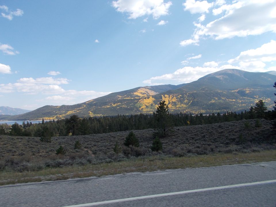 Mountain landscape with autumn foliage and a road in the foreground