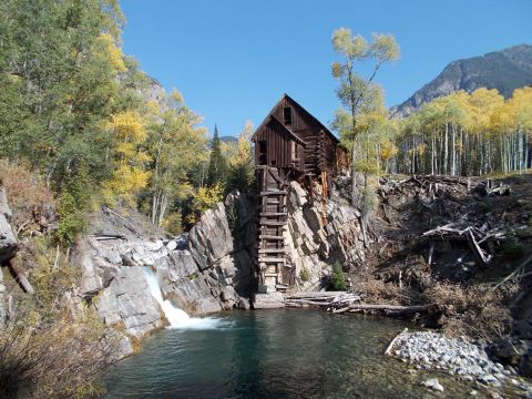 1986 Ford Bronco II - An old wooden mill sits precariously on a cliff above a pool fed by a waterfall.