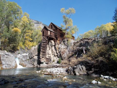 1986 Ford Bronco II - Historic mill building on a cliffside with a waterfall and river in the foreground.
