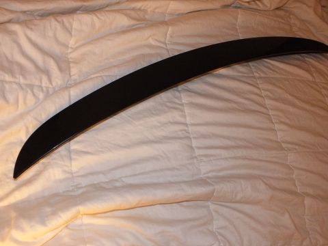 2003 Ford Crown Victoria - Glossy black decklid spoiler photographed top-down on a quilted comforter
