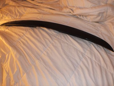 2003 Ford Crown Victoria - Black rear deck spoiler shown at an angle on a gray comforter