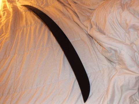 2003 Ford Crown Victoria - Curved black decklid spoiler laid diagonally across a quilted bedspread