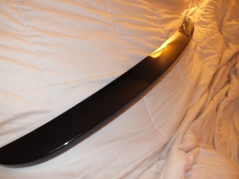 2003 Ford Crown Victoria - Low-angle view along the edge of a black decklid spoiler on bedding